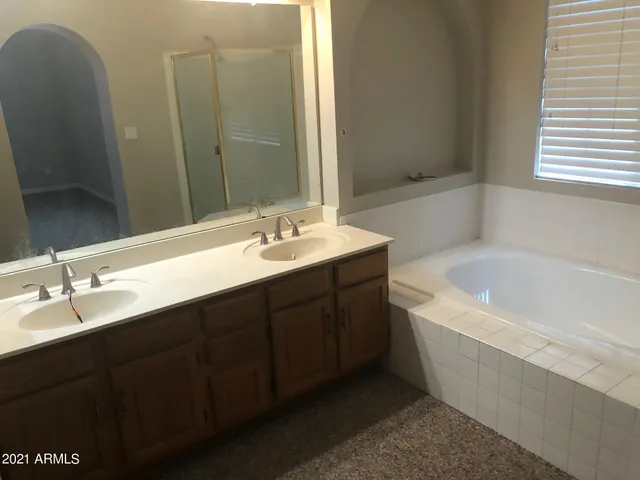 a bathroom with a tub sink and mirror