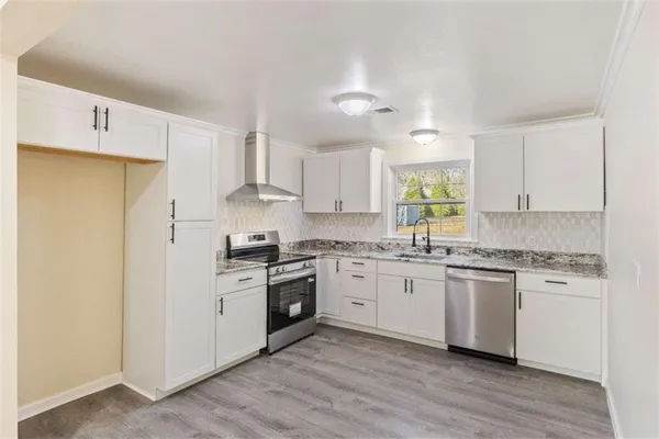 a kitchen with a stove cabinets and window