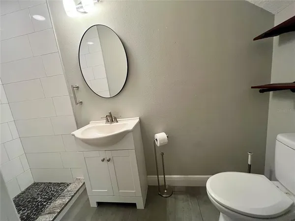 a bathroom with a sink toilet and a mirror