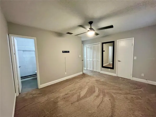 an empty room with closet and windows