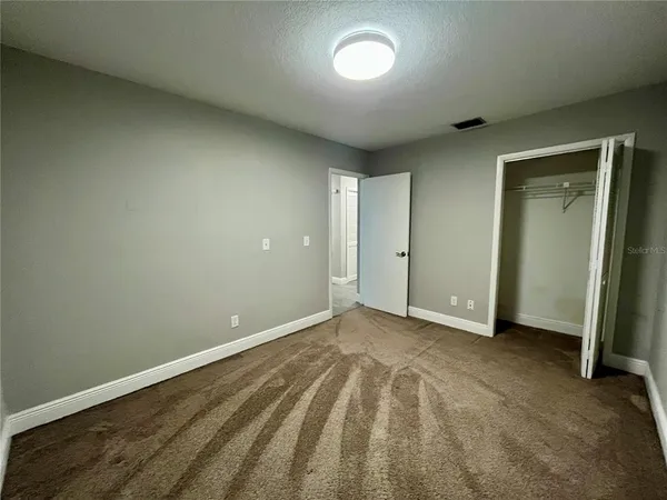 an empty room with wooden floor and closet