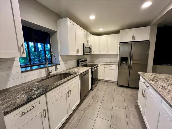a kitchen with a sink a refrigerator and cabinets