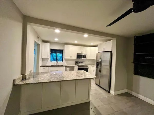 a kitchen with stainless steel appliances granite countertop a refrigerator and a sink