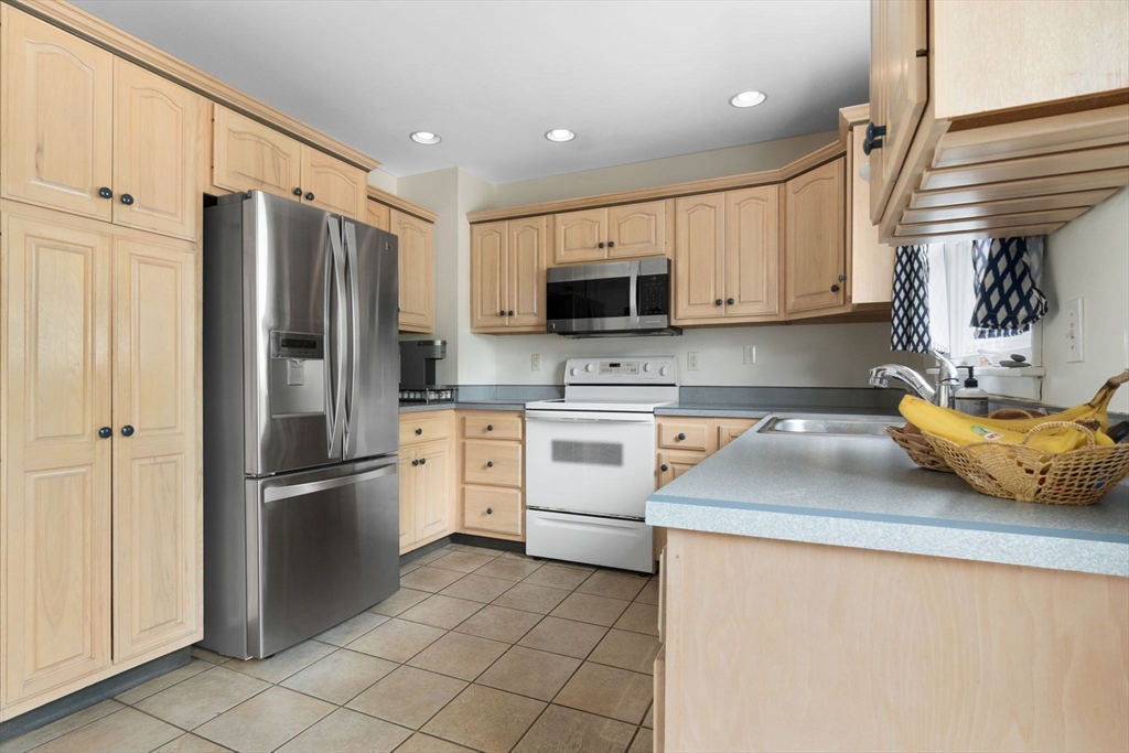 476 Winnacunnet Road, Unit 1 Hampton, NH 03842 - Photo 11 of 34 a kitchen with stainless steel appliances a refrigerator sink and microwave