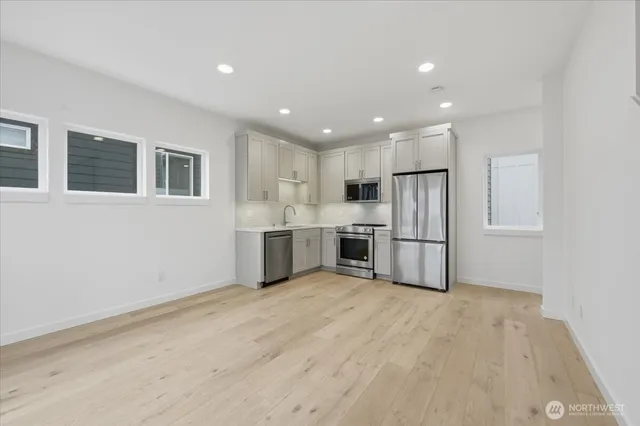 a kitchen with stainless steel appliances a refrigerator sink and microwave