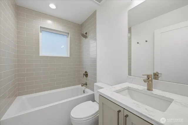 a bathroom with a granite countertop sink toilet and bathtub