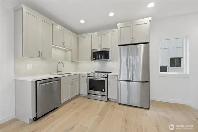 a kitchen with a refrigerator stove and white cabinets