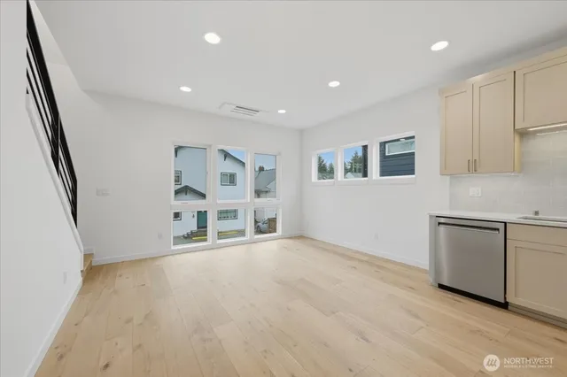 a view of an empty room with window and wooden floor