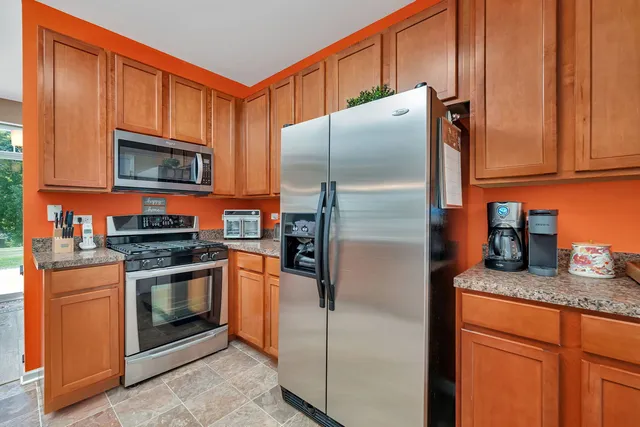 a kitchen with granite countertop stainless steel appliances and wooden cabinets