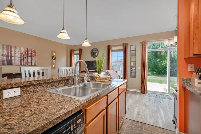 a kitchen with granite countertop a sink a counter top space and living room view