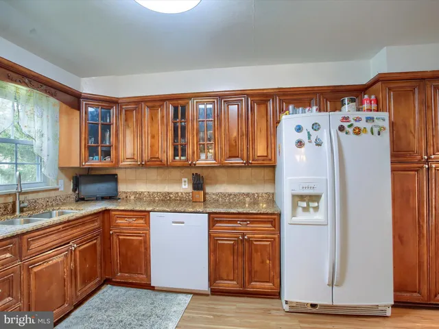 a kitchen with granite countertop a refrigerator and a sink