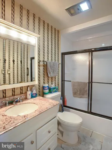 a bathroom with a granite countertop sink toilet and shower