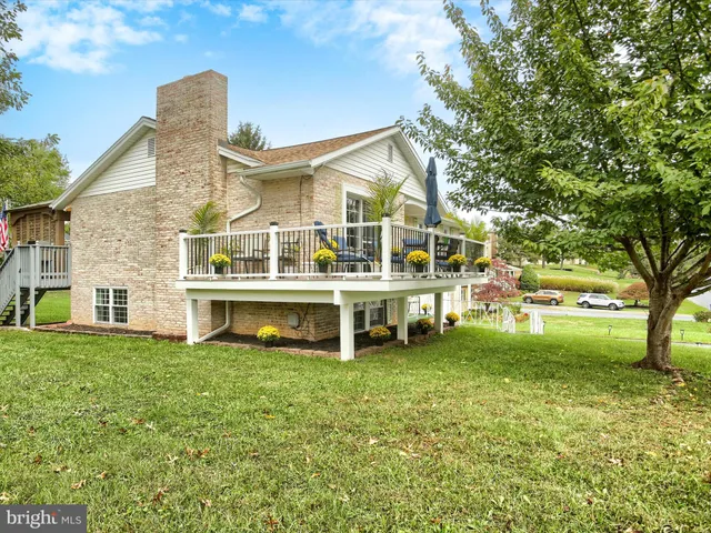 a view of a house with a big yard and large trees