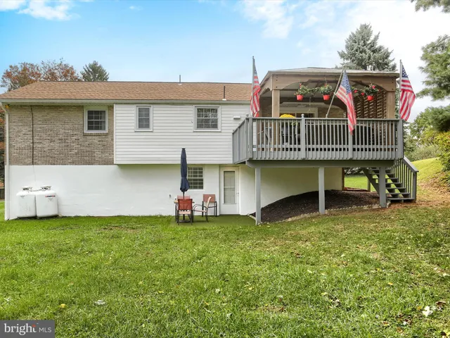 a view of a house with backyard and sitting area