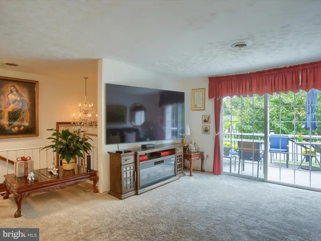 a living room with furniture a flat screen tv and a large window