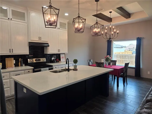 a kitchen with a table chairs and a chandelier