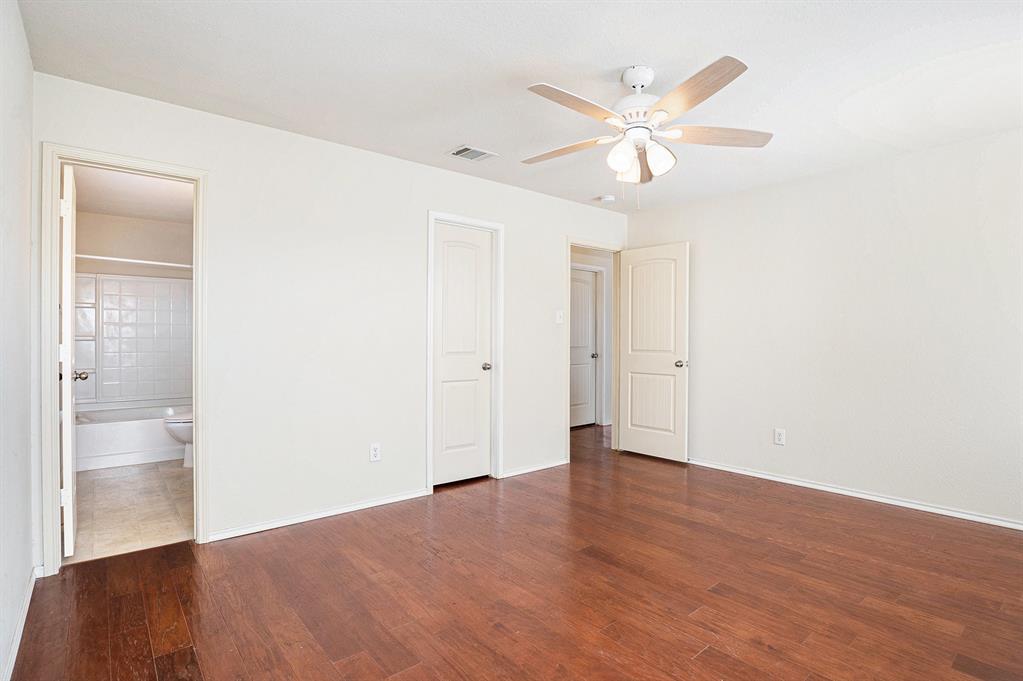 2120 Bliss Road Fort Worth, TX 76177 - Photo 15 of 25 Unfurnished bedroom featuring dark wood finished floors, ceiling fan, and connected bathroom
