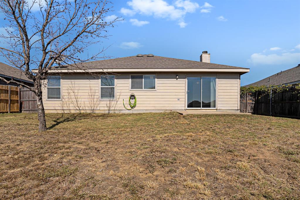 2120 Bliss Road Fort Worth, TX 76177 - Photo 22 of 25 Rear view of house with a fenced backyard and a chimney