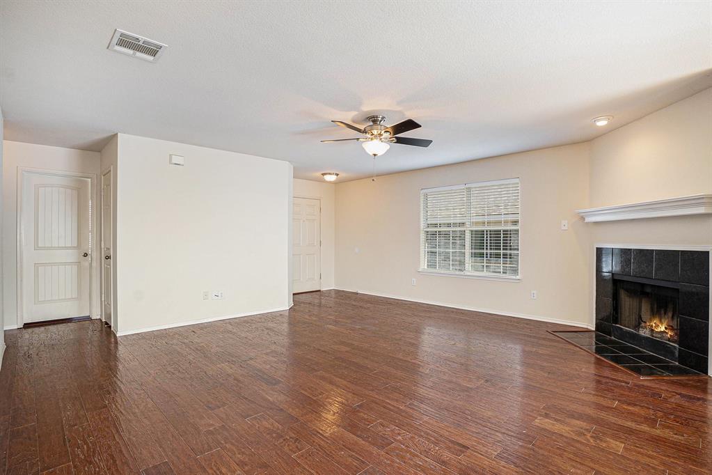 2120 Bliss Road Fort Worth, TX 76177 - Photo 5 of 25 Unfurnished living room with a fireplace, dark wood-type flooring, and a ceiling fan