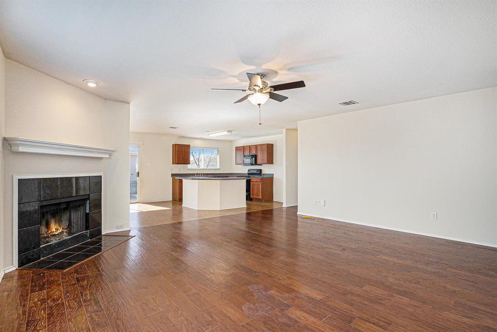 2120 Bliss Road Fort Worth, TX 76177 - Photo 7 of 25 Unfurnished living room featuring ceiling fan, dark wood finished floors, and a tiled fireplace