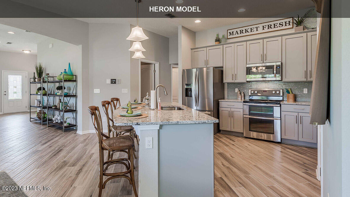65712 Edgewater Drive Yulee, FL 32097 - Photo 10 of 45 a kitchen with stainless steel appliances a stove a sink island and a refrigerator