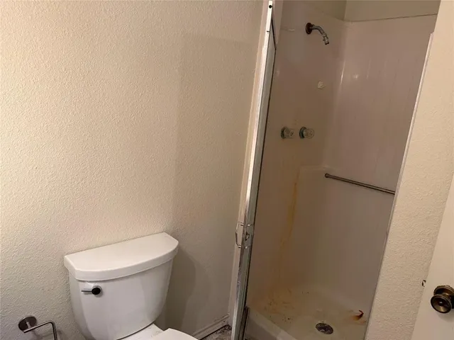 a white toilet sitting next to a shower