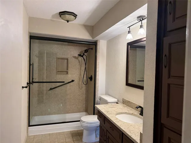a bathroom with a granite countertop sink toilet and shower