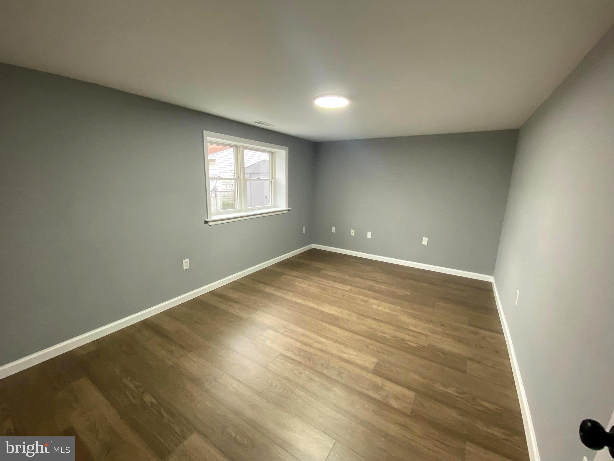 15 East 8th Avenue Pine Hill, NJ 08021 - Photo 18 of 32 an empty room with wooden floor and windows