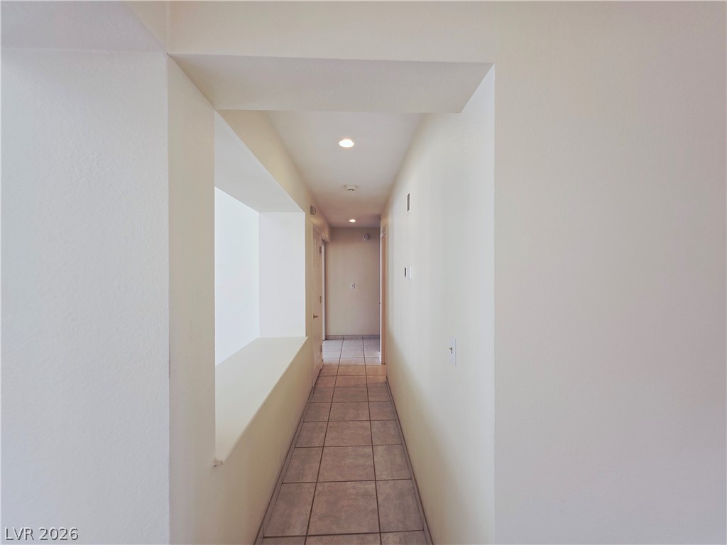 2920 Setting Sun Street Las Vegas, NV 89117 - Photo 34 of 43 A well-lit hallway with tile flooring leads to a series of doors.