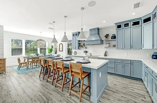 a kitchen with stainless steel appliances granite countertop a sink a stove and a wooden floors