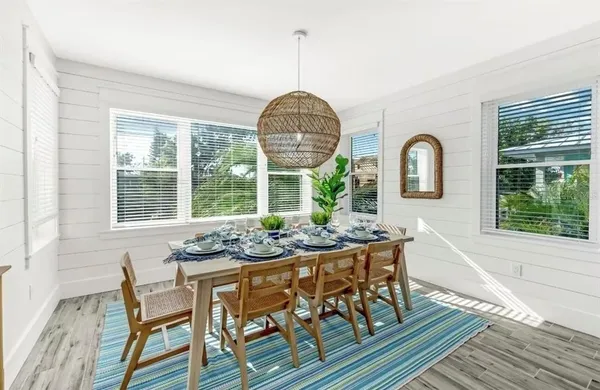 a dining room with furniture a chandelier and wooden floor