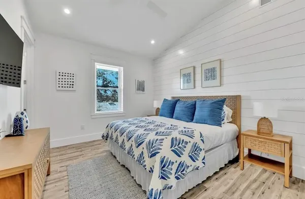 a bedroom with a bed and a flat screen tv