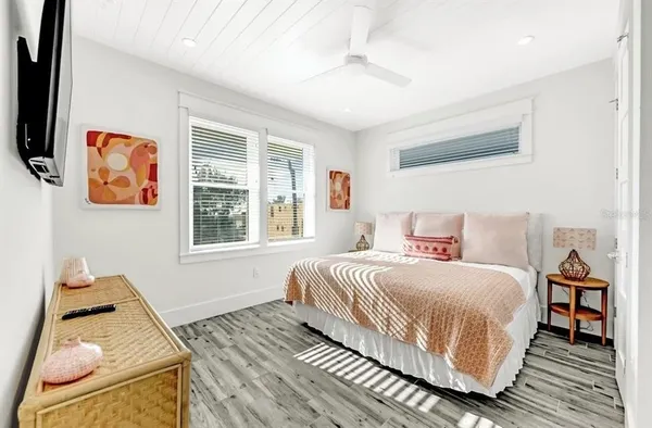 a bedroom with a bed and wooden floor