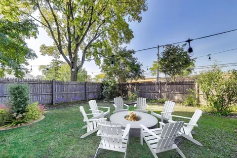a view of a chair and table in backyard of the house