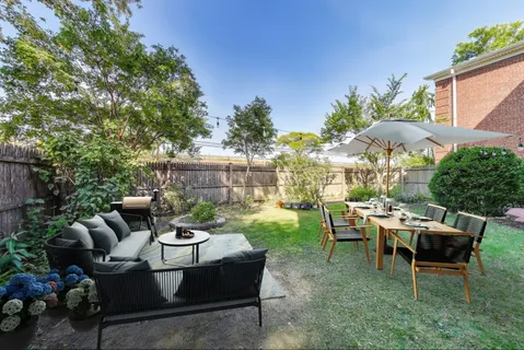 a view of a patio with table and chairs potted plants and a large tree