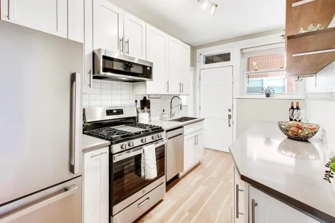 a kitchen with stainless steel appliances a sink a stove and cabinets