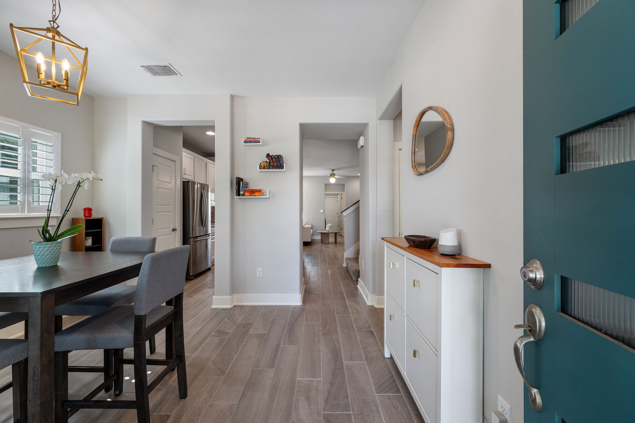 5409 Fox Wing Way Austin, TX 78747 - Photo 3 of 26 A striking teal entrance door opens into an inviting home with sleek flooring and natural light.