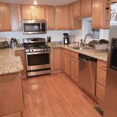 a kitchen with granite countertop a refrigerator and a stove top oven