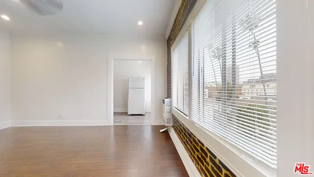 a view of a room with wooden floor and a window