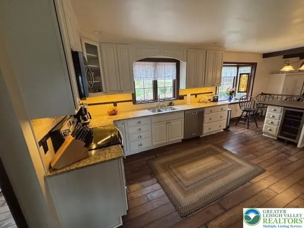 a large kitchen with a stove a sink dishwasher and a stove with wooden floor