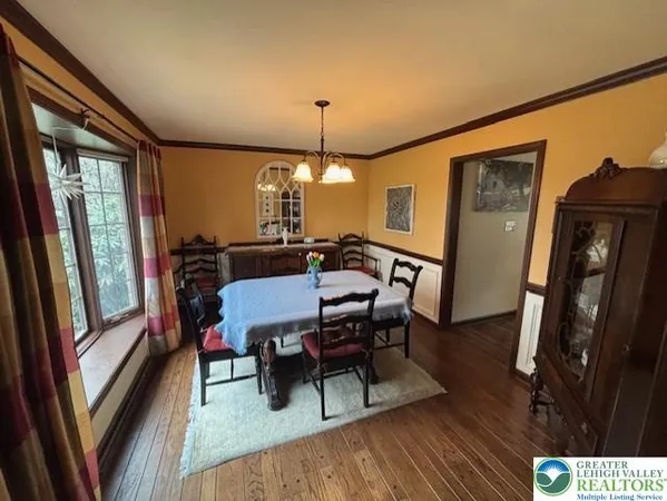 a view of a a dining room with furniture window and wooden floor