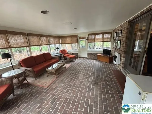 a living room with furniture a large window and a flat screen tv