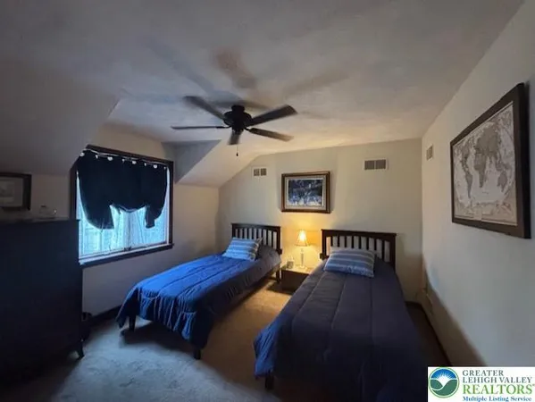a bedroom with two beds and a painting on the wall