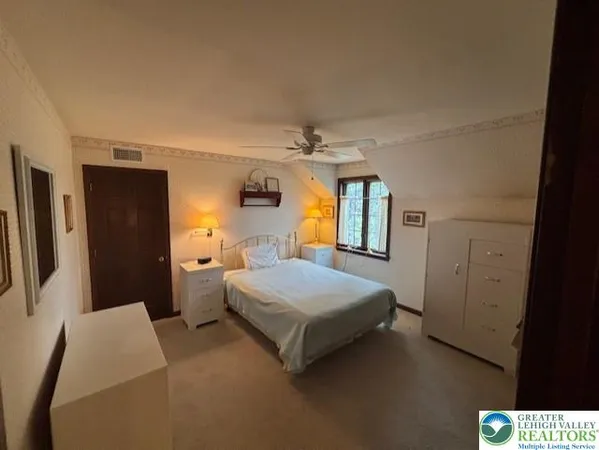 a bedroom with a bed lamp and a dresser