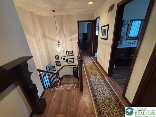 a view of a hallway with wooden floor and stairs