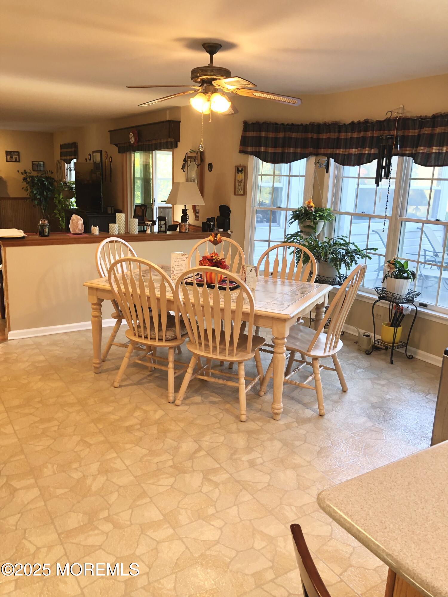 10 Saddlebrook Road Millstone Township, NJ 08535 - Photo 37 of 86 a dining room with furniture a chandelier and a flat screen tv