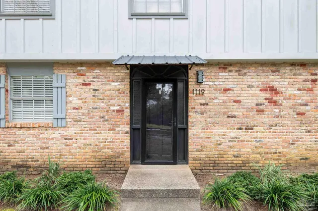a view of a hallway with wooden floor and entryway