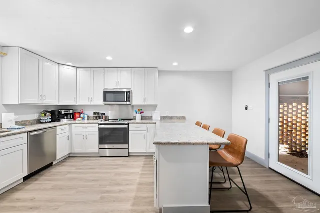a kitchen with a dining table chairs sink and cabinets