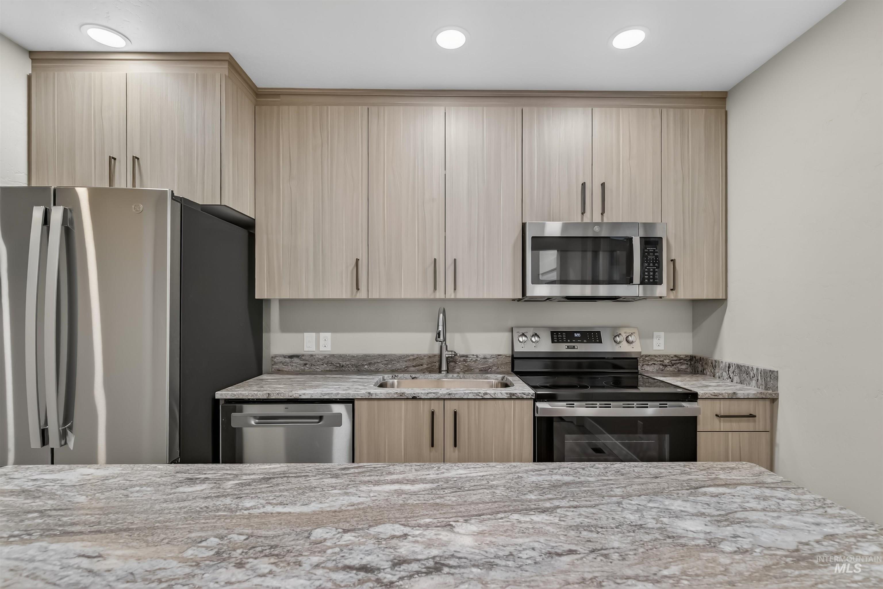 929 10th Street Clarkston, WA 99403 - Photo 11 of 43 Kitchen with stainless steel appliances, light stone counters, light brown cabinetry, and recessed lighting