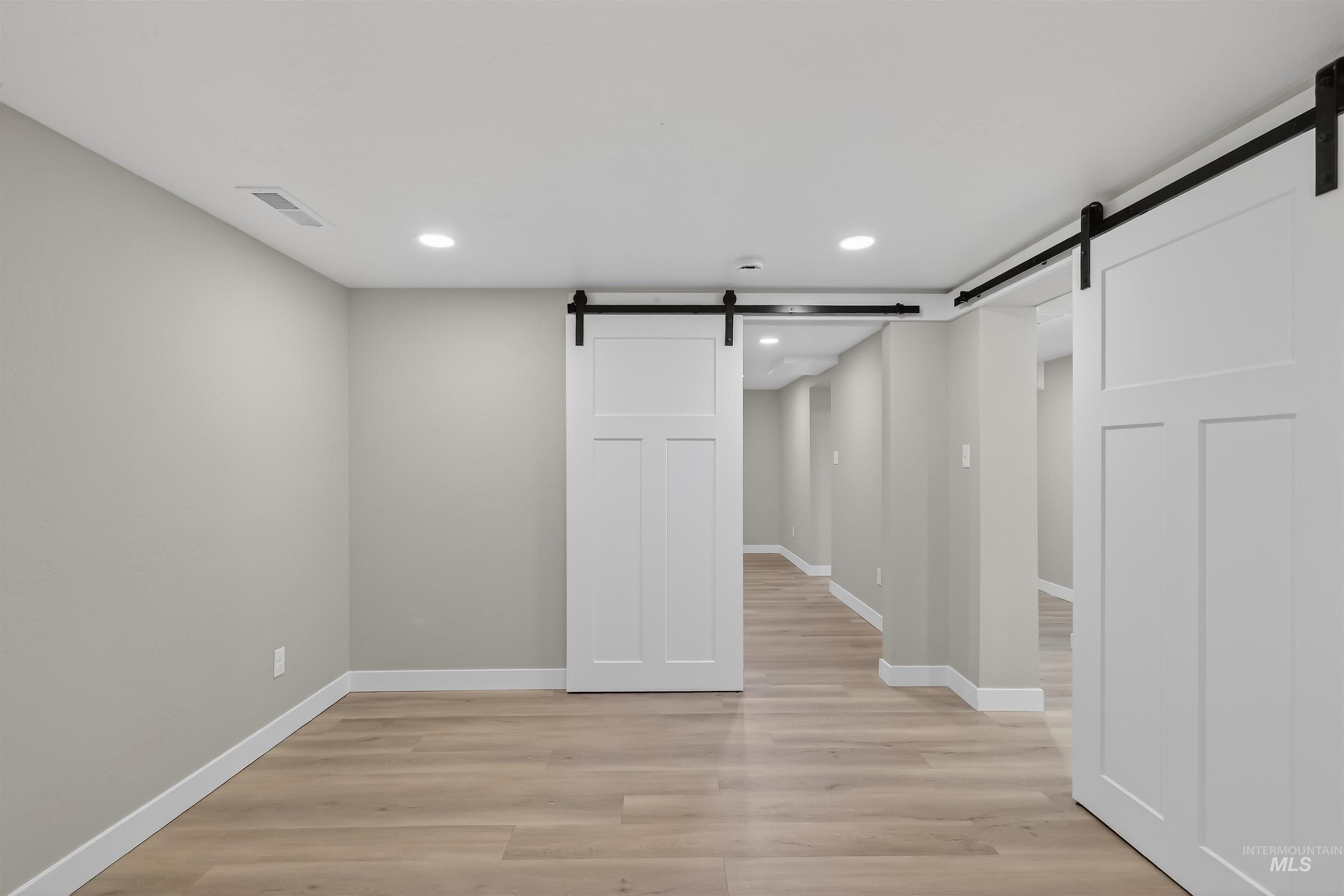 929 10th Street Clarkston, WA 99403 - Photo 22 of 43 Basement featuring a barn door, light wood-style floors, and recessed lighting